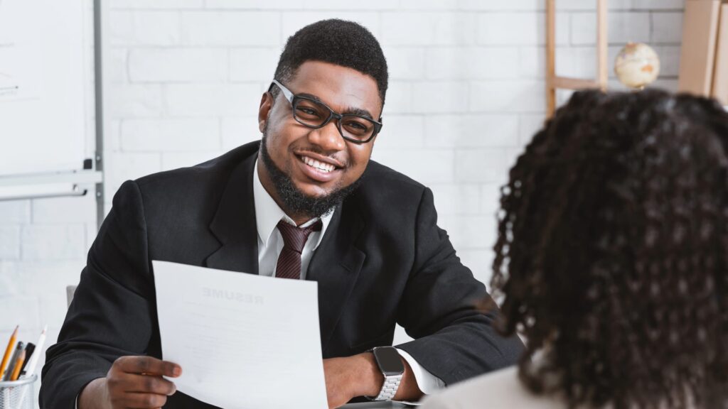 Young Man At Interview With Resume In Hand